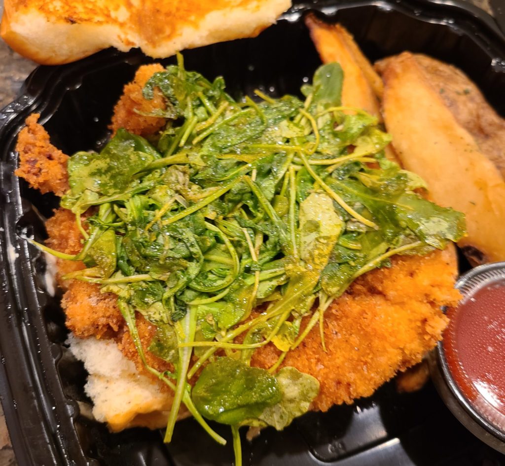 arugula and crispy chicken sandwich at nomad by fartley farms